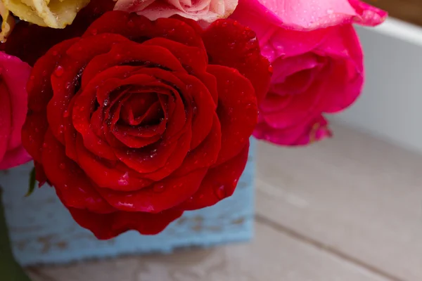 Rosas rojas y rosas sobre la mesa — Foto de Stock