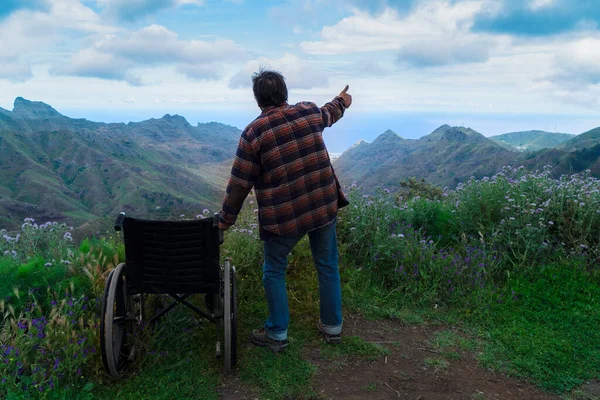 Engelli kadın dağ tepesinde tekerlekli sandalyede manzaranın keyfini çıkarıyor. — Stok fotoğraf