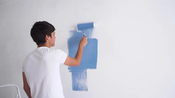 白にブルーの色で若い男の絵画壁漆喰の部屋 — ストック写真