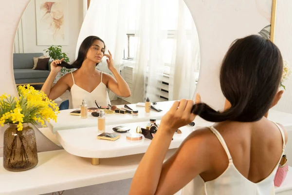 Morena mujer con el pelo largo y oscuro y la piel limpia haciendo la rutina de maquillaje —  Fotos de Stock