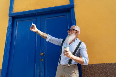 Telefonu olan yaşlı bir adam.