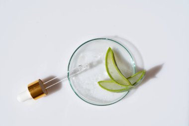 Cilt bakımı için şeffaf serum içeren cam petri kabı.