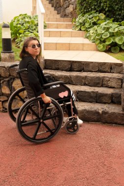 Engelli kadın dağ tepesinde tekerlekli sandalyede manzaranın keyfini çıkarıyor.