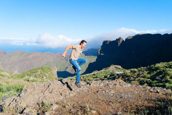 Feliz hombre de mediana edad viajero sonriendo a la cámara mientras camina en las montañas — Foto de Stock