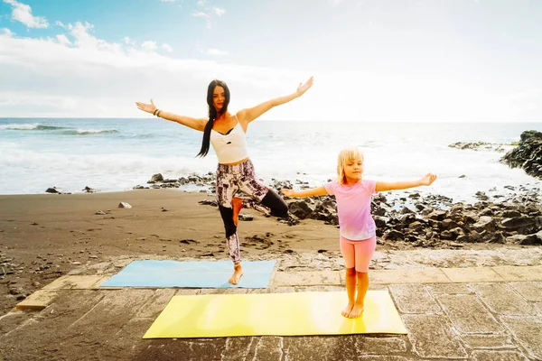 Zdrowa szczęśliwa rodzina mama i córka robi ćwiczenia rozciągające na wybrzeżu — Zdjęcie stockowe