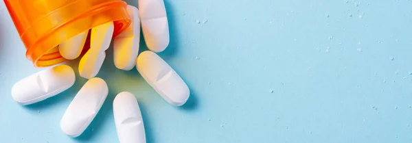 Pílulas brancas em fundo azul — Fotografia de Stock