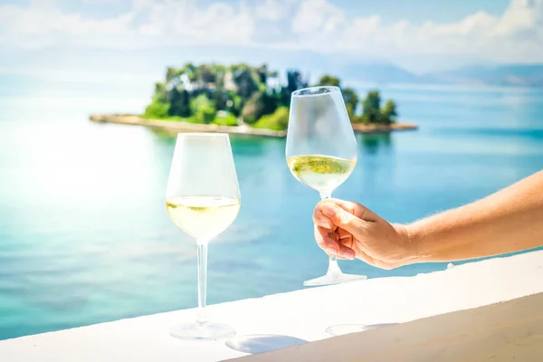 Kaksi lasia valkoviiniä Korfun kanssa taustalla — kuvapankkivalokuva