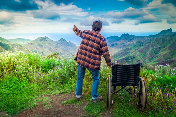 Engelli kadın dağ tepesinde tekerlekli sandalyede manzaranın keyfini çıkarıyor. — Stok fotoğraf