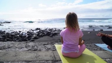 Spor kıyafetleriyle sabahları yoga ve meditasyon yapan küçük bir kız.