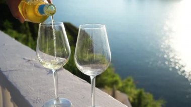 Arka planda Korfu olan iki kadeh beyaz şarap.