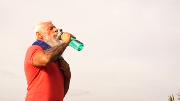 上了年纪的快乐男人 留着白胡子 在户外运动后喝水 — 图库视频影像