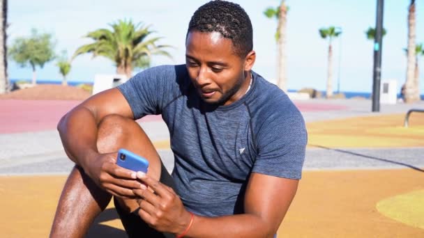Sport Træning Afrikanske Amerikanske Mænd Hviler Med Telefon Efter Træning – Stock-video