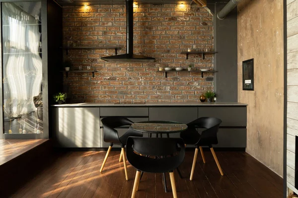 dark stylish kitchen with hood, shelves and dinning table