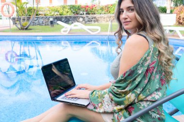 woman working or studing online in relaxed ambient, happy woman using modern laptop computer near pool while remote working or playing clipart