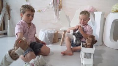 Çocuklar evdeki odada oynuyorlar, iki tatlı çocuk bir şey hakkında konuşuyorlar.