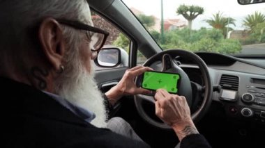 Arabadaki son sınıf öğrencisi seyir subayı olarak yeşil ekranlı cep telefonu kullanıyor.