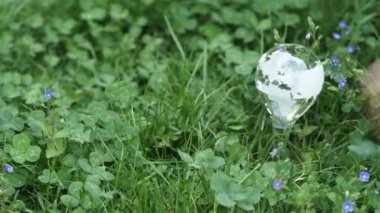 placing watering glass with earth map in garden, earth protection and sustainable ecology development concept, modern gardening and earth care