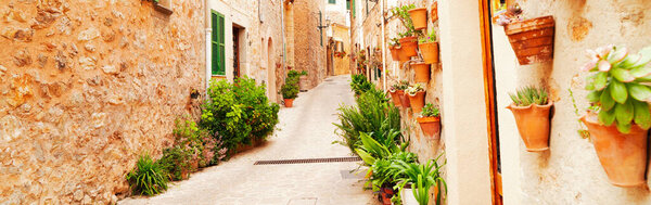 Street in old town of Valdemossa with traditional flower pots, Majorca, Spain, Belearic islands, web banner