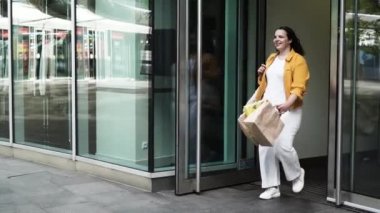 Happy curvy woman with ecologic craft shopping bags enjoying in shopping. Consumerism, shopping, lifestyle concept