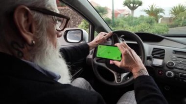 Arabadaki son sınıf öğrencisi seyir subayı olarak yeşil ekranlı cep telefonu kullanıyor.