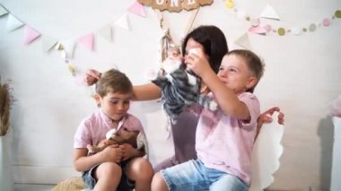Çocuklar anneleriyle evdeki odada oynuyorlar, iki küçük tatlı çocuk ve annesi bir şey hakkında konuşuyorlar.