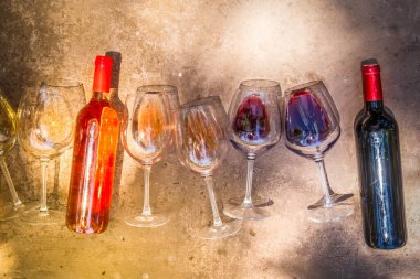 pink, white and red wine in glasses with bottles with shadows overlay with sunshine