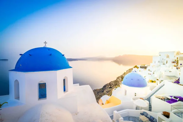 传统的希腊村庄Oia Santorini 蓝色圆顶的教堂和村庄屋顶在柔和的晨光中 希腊阳光普照 — 图库照片
