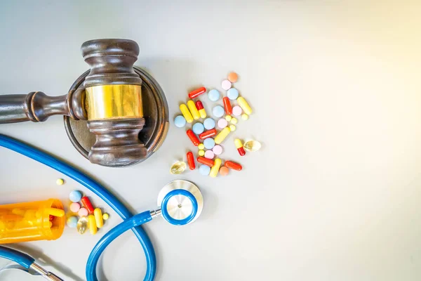 law gavel, stethoscope and pills, medical law concept