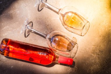 Pembe şarap bardaklarda ve şişelerde. Yakın çekim, üst manzara.