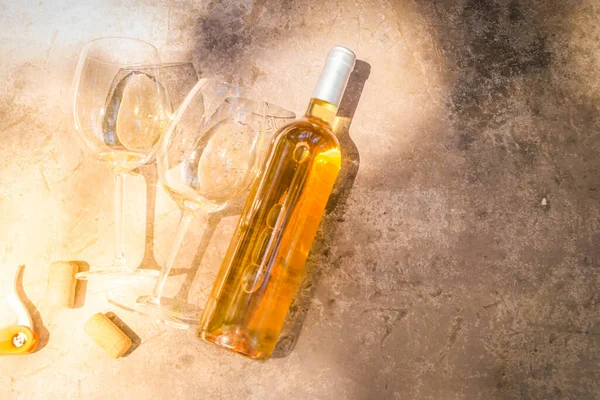 Pembe şarap bardaklarda ve şişelerde. Yakın çekim, üst manzara.