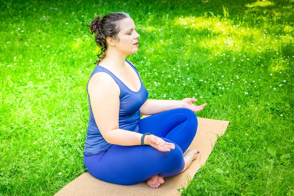 Woman and sports, exercise for weight loss and relaxation in the fresh air. Happy curvy 40s woman doing workout yoga routine outdoor at city park