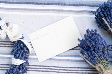 Dry lavender flowers over cloth background with copy space on blank card