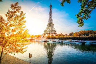 Paris Eiffel Tower and river Seine with sunrise sun in Paris, France. Eiffel Tower is one of the most iconic landmarks of Paris, fall day with sunshine