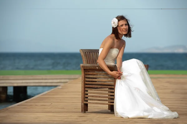 Sposa siede sulla riva del mare — Foto Stock