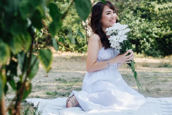 Mujer Asiática Sonriente Sentada Una Manta Parque Sosteniendo Ramo Flores — Foto de Stock