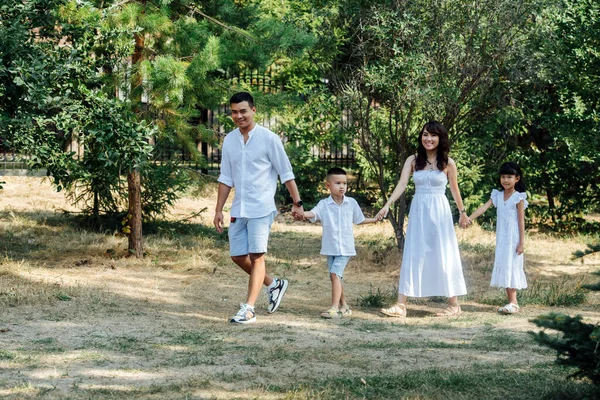 Beyaz Elbiseli Sevimli Asyalı Bir Aile Parktaki Çimenlerde Yürüyüş Yapıyor — Stok fotoğraf
