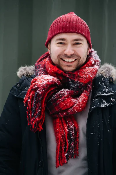 一个穿着雪白冬衣的积极中年男子的画像 他戴着充满活力的红帽子和围巾 笑的时候露出牙齿 — 图库照片