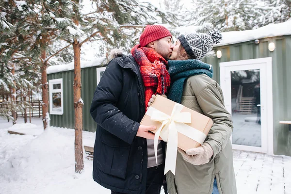 Чоловік Зимовому Одязі Цілує Свою Жінку Подарувавши Подарунок Стоїть Перед — стокове фото