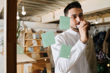 Ahşap bir çerçeveye temiz bir plastik tahta üzerine yazılı bir tişört giymiş ciddi bir yüz yöneticisi. Ön görünüm.
