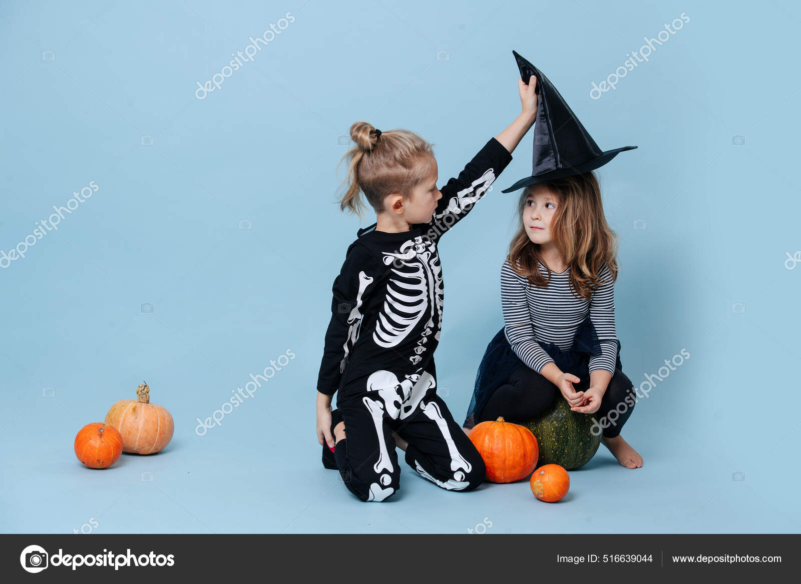 Garçon en costume squelette prenant un chapeau de sorcière d'une fille,  elle le regarde. — Photo de stock par ©zzzdim - 516639044, image size:1600x1167