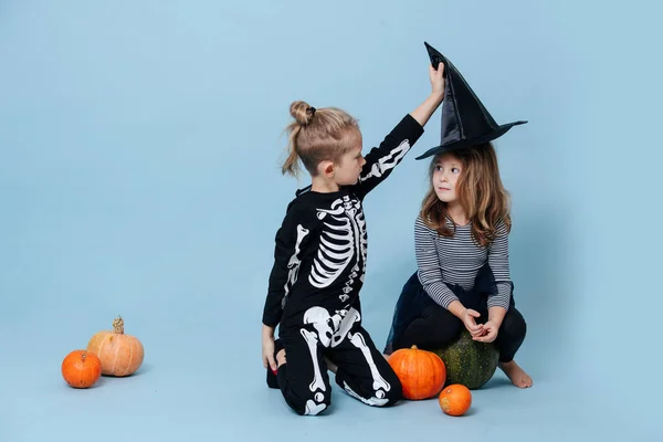 Ragazzo in costume da scheletro che si toglie un cappello da strega da una ragazza, lei lo guarda. — Foto Stock