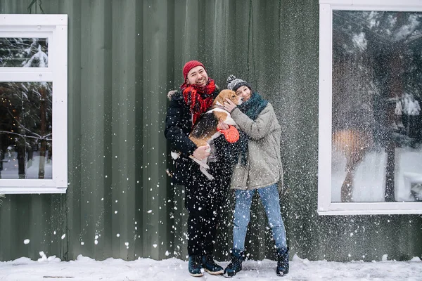 Мила пара позує на фото зі своїм бігль на відкритому повітрі взимку — стокове фото