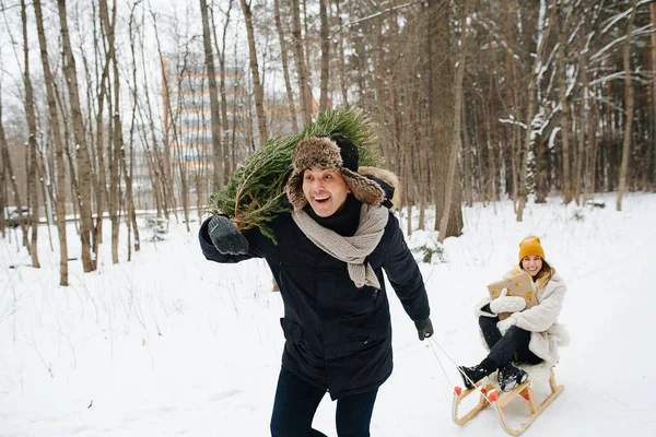 Щаслива Пара Чоловік Ялинкою Плечі Пробігає Через Зимовий Парк Тягне — стокове фото