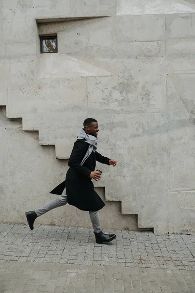 Felemelt Fekete Férfi Őszi Kabátban Gyorsan Sétál Valahol Kezében Egy — Stock Fotó