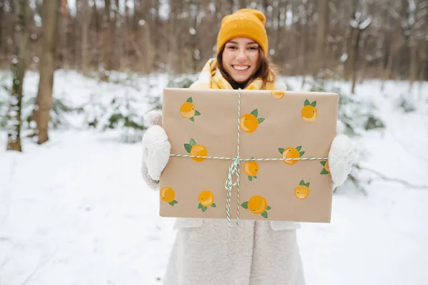 Дівчина Зимовому Одязі Стоїть Парку Вона Тримає Подарунок Витягнутих Руках — стокове фото