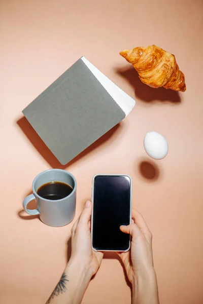 Foto Maken Een Telefoon Koffiemok Een Perzikkleurig Oppervlak Croissant Notebook — Stockfoto