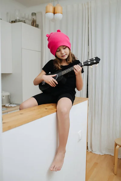 Сидя Высоком Столе Маленькая Девочка Розовой Шляпе Играет Гитаре Ноги — стоковое фото