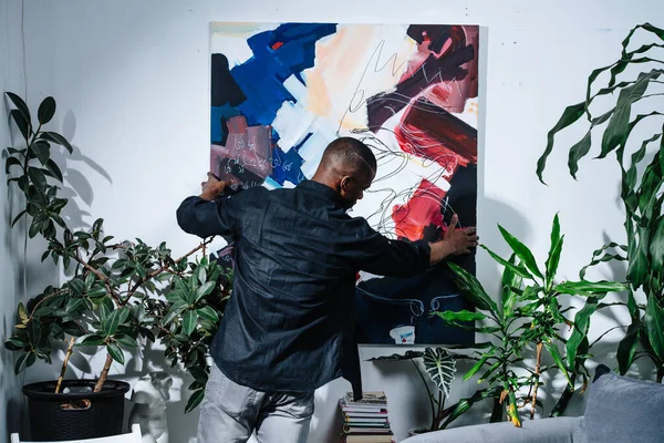 Pintor Afroamericano Colgando Pieza Colorida Abstracta Pared Plantas Maceta Alrededor —  Fotos de Stock