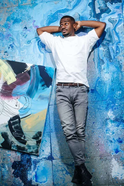 추상적 파란색 페인트 바닥에 차가운 미술가가 보인다 다리를 구부려 — 스톡 사진