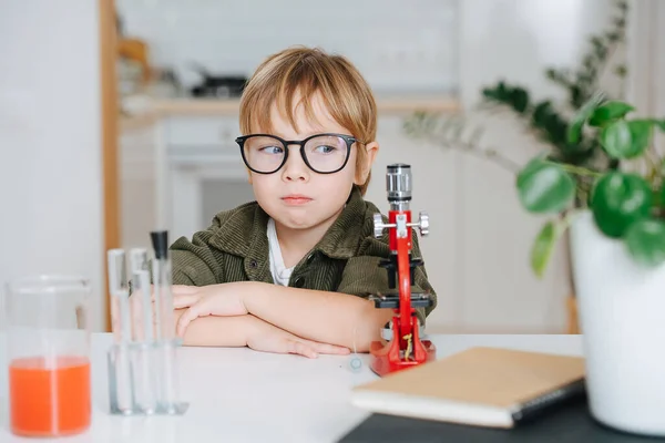Неприємний Маленький Хлопчик Окулярах Сидить Столом Перед Мікроскопом Кухні Руки — стокове фото